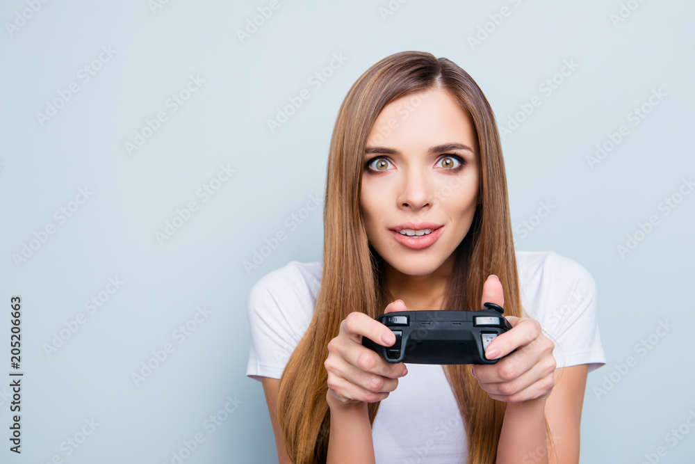Portrait with copy space empty place of funny playful girl holding joystick in hands she is video game lover playing with spectacular expression isolated on grey background Portrait with copy space empty place of funny playful girl holding joystick in hands she is video game lover playing with spectacular expression isolated on grey background