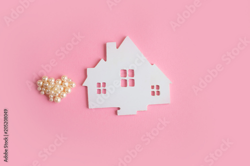 Concept white house on a pink background. Family cosiness