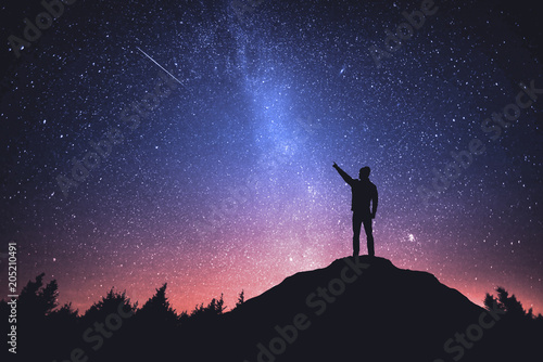Night sky with stars and silhouette of a standing man