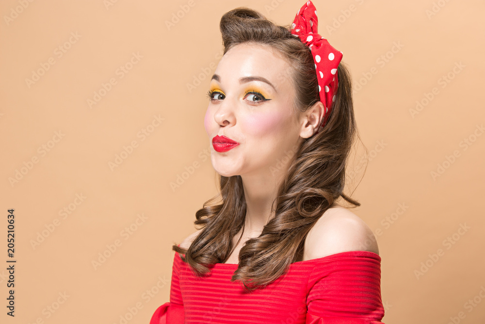 Beautiful young woman with pinup make-up and hairstyle. Studio shot on pastel background Beautiful young woman with pinup make-up and hairstyle. Studio shot on pastel background
