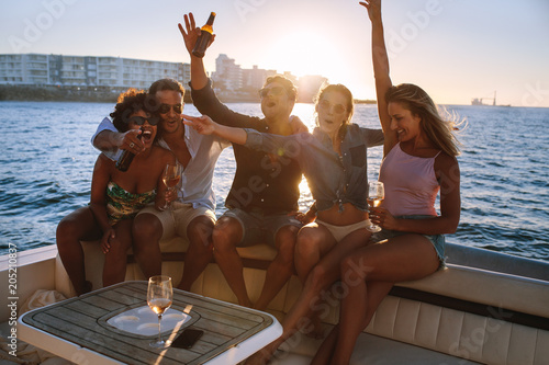 Wall Mural Cheerful friends partying on boat