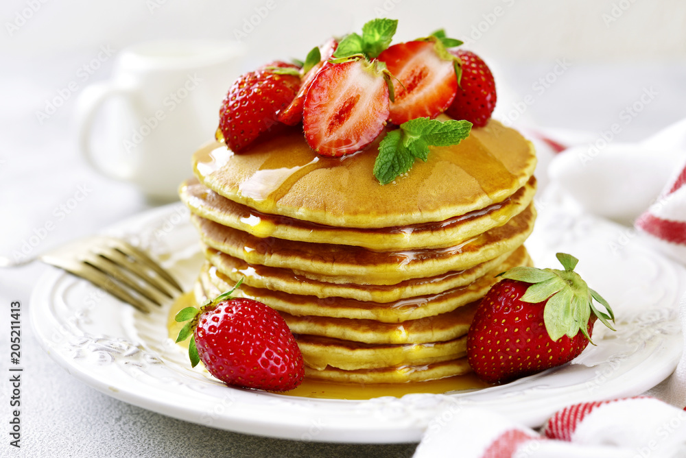 Stack of delicious pancakes with maple syrup and fresh strawberry for a breakfast. Stack of delicious pancakes with maple syrup and fresh strawberry for a breakfast.