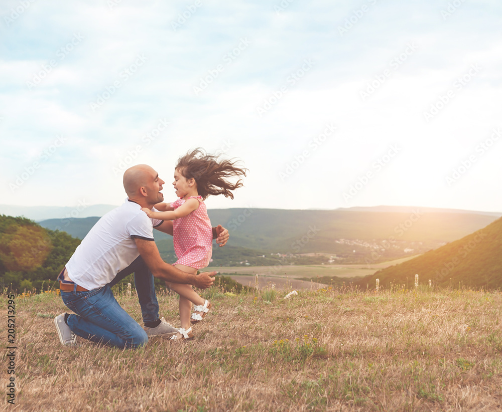 Fototapeta premium Father holds his pretty daughter and they are hug