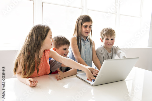 Group of curious children watching stuff on the laptop screen