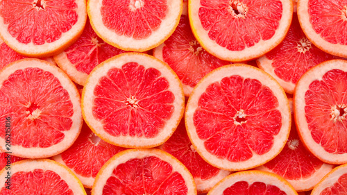 Grapefruit red juicy slices background. top view