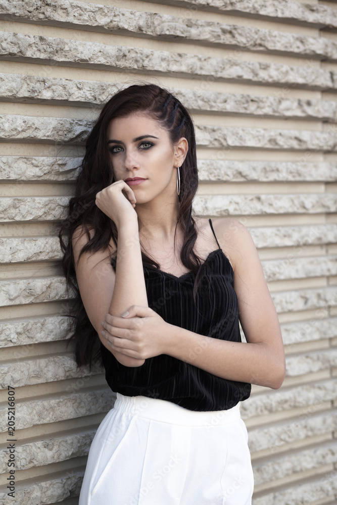 Portrait of brunette girl with in trendy posed at sunset
