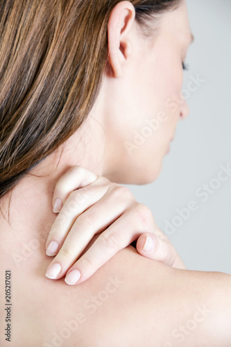 Studio shot of young woman with neck pain