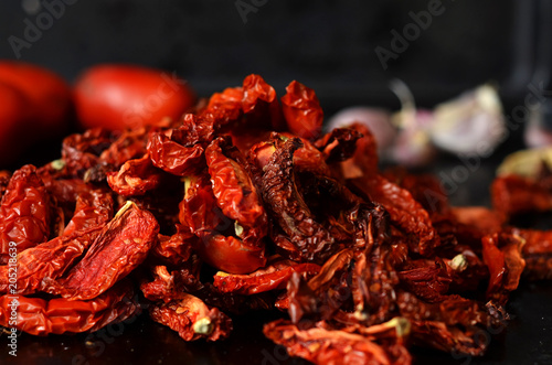 Heap of dried tomatoes on a black background