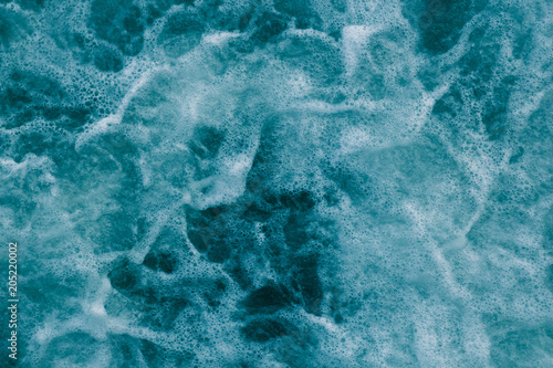 Bright abstract light turquoise background, water with white foam and bubbles © Bogdan