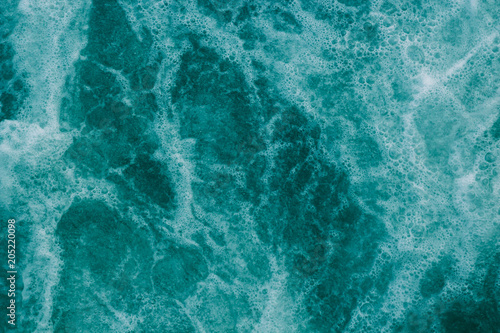 Bright abstract light turquoise background, water with white foam and bubbles