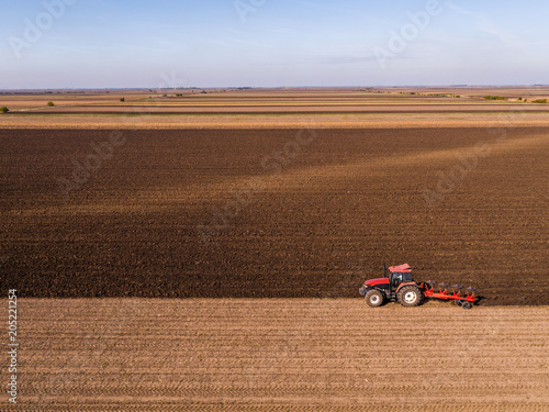 Принти на полотні Aerial shot of a farmer plowing stubble field