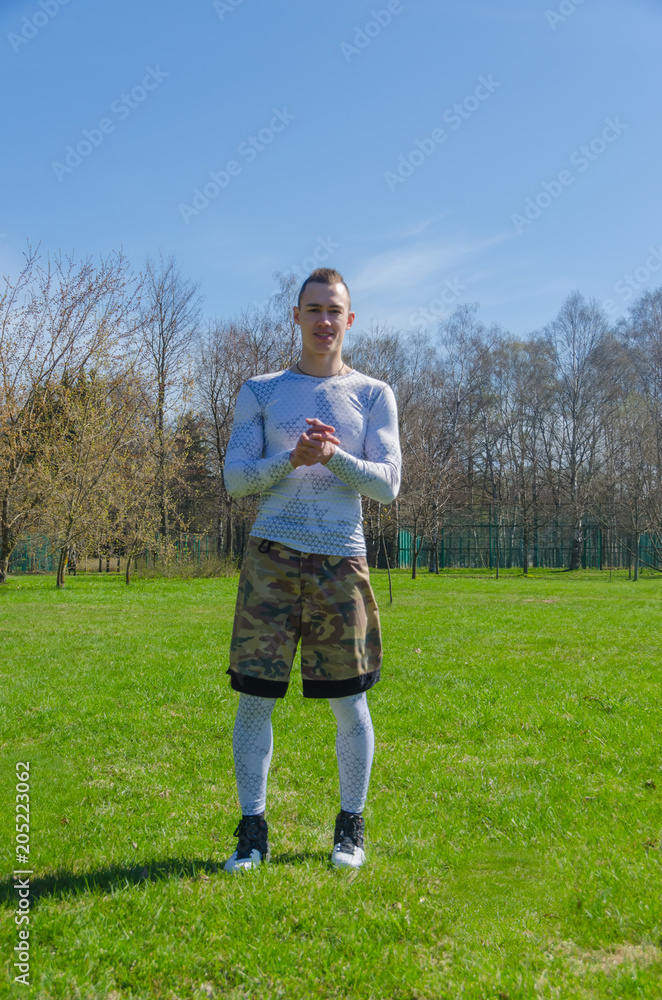 a man in sports clothes in the summer, trains in the Park