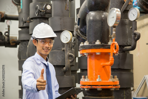 Engineer checking Condenser Water pump and pressure gauge , chiller water pump with pressure gauge. © A Stockphoto