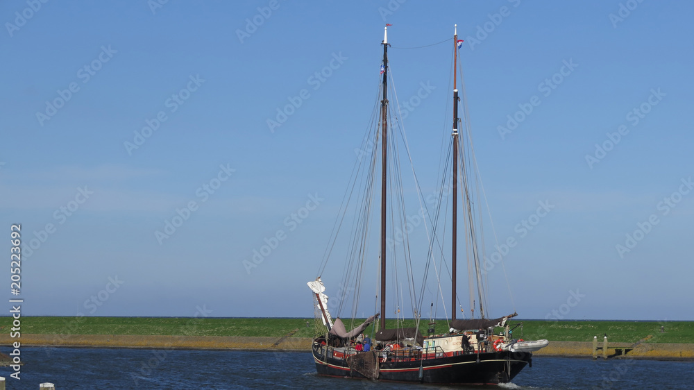 Traditional Dutch sailing ship leaving harbor
