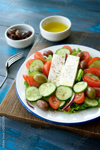 Traditional Greek salad. Light and healthy food. Blue food background 