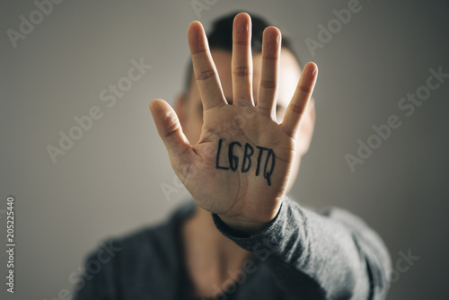 man with the text LGBTQ in his hand