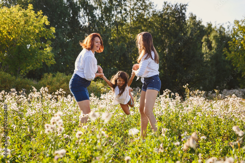 Fototapeta premium happy family playing with baby on the lawn in summer