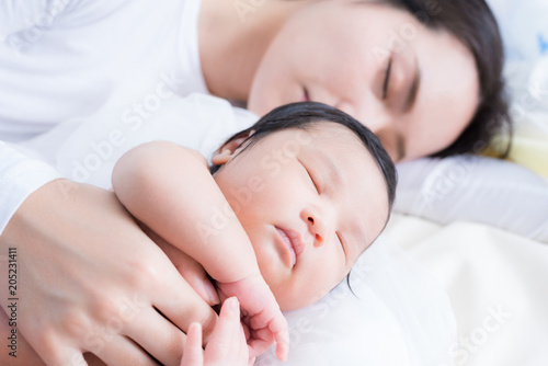 happy mother with baby in bed