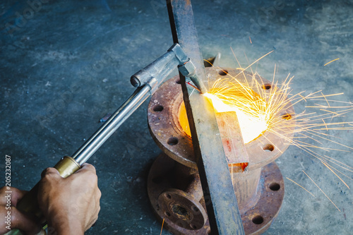 the worker cutting steel with an industrial cutter.