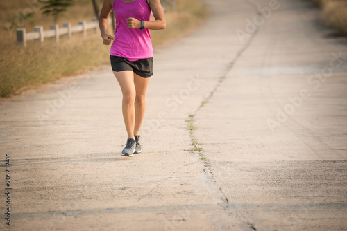 Young lady running on a rural road during sunset, sports, healthy lifestyle