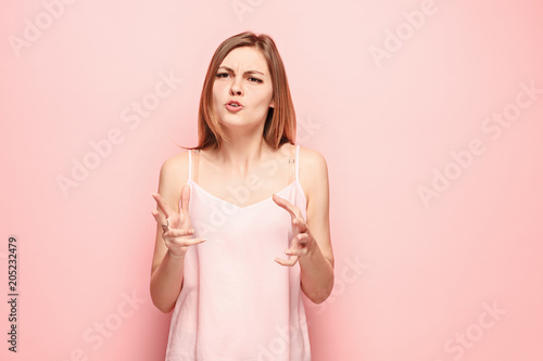 Beautiful female half-length portrait isolated on pink studio backgroud. The young emotional surprised woman