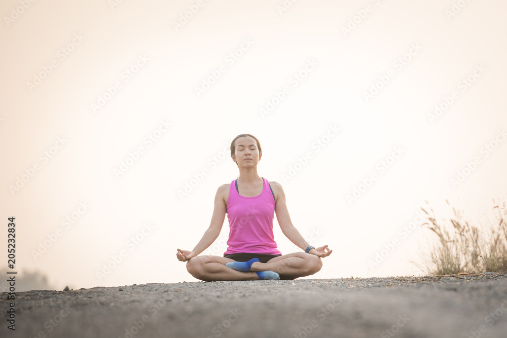 woman practices yoga and meditates in the lotus position