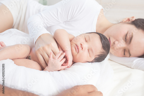 happy mother with baby in bed