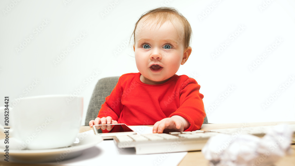 Happy child baby girl toddler sitting with keyboard of computer isolated on a white background Happy child baby girl toddler sitting with keyboard of computer isolated on a white background