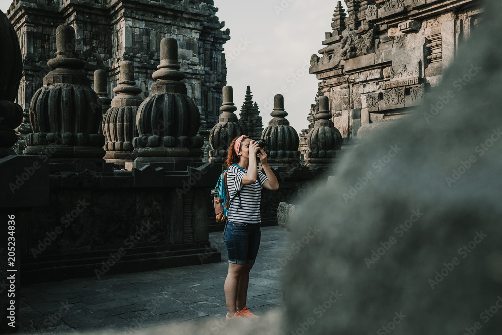 Young tourist woman takin pictures of the amazing Candi Prambanan or Rara Jonggrang, largest Hindu temple site in Indonesia. Yogyakarta, Java. Travel photography. Young tourist woman takin pictures of the amazing Candi Prambanan or Rara Jonggrang, largest Hindu temple site in Indonesia. Yogyakarta, Java. Travel photography.