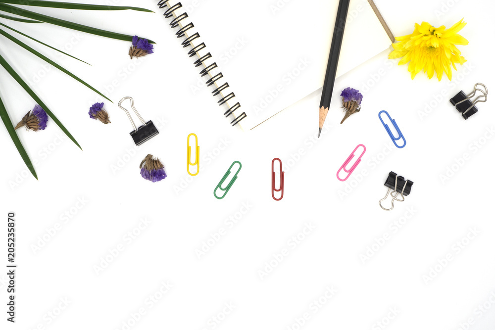 top view book, pencil for note isolated on white background with colorful paper clip, black paper clip decorate by chrysanthemum, yellow and purple flower, green leave. Desk office concept, copy space top view book, pencil for note isolated on white background with colorful paper clip, black paper clip decorate by chrysanthemum, yellow and purple flower, green leave. Desk office concept, copy space