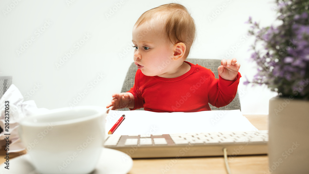 Happy child baby girl toddler sitting with keyboard of computer isolated on a white background Happy child baby girl toddler sitting with keyboard of computer isolated on a white background