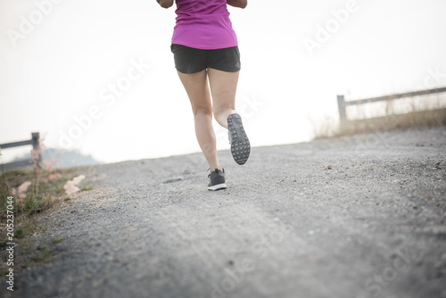 Young lady running on a rural road during sunset, sports, healthy lifestyle