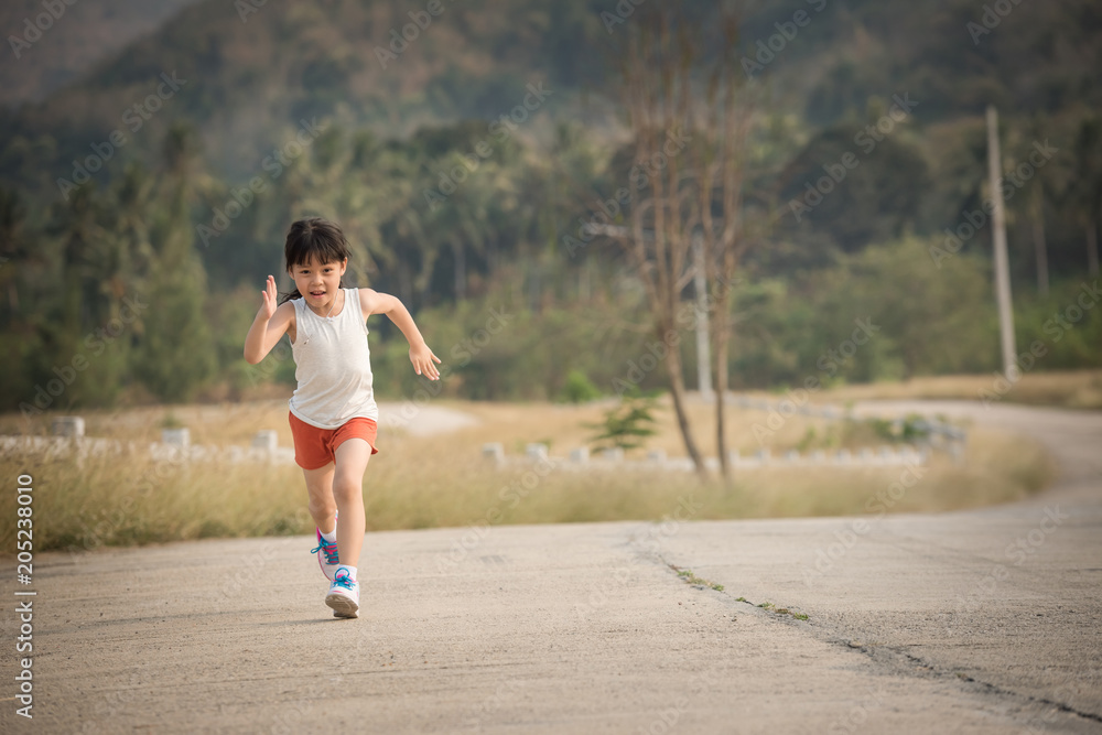 Little girl running running on the road in the countryside, sports, healthy lifestyle