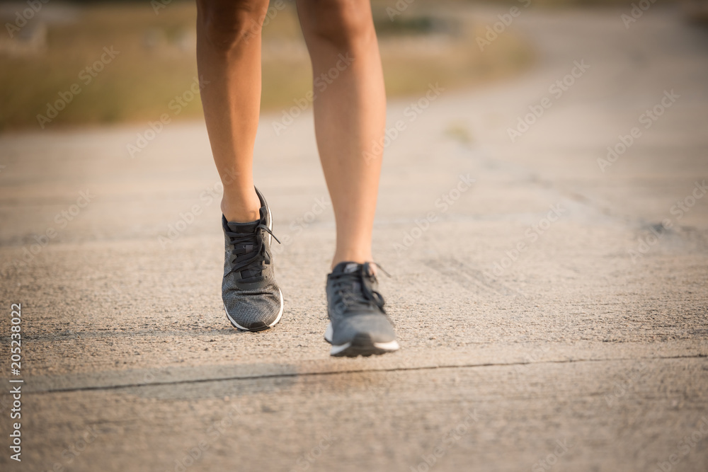 Young lady running on a rural road during sunset, sports, healthy lifestyle