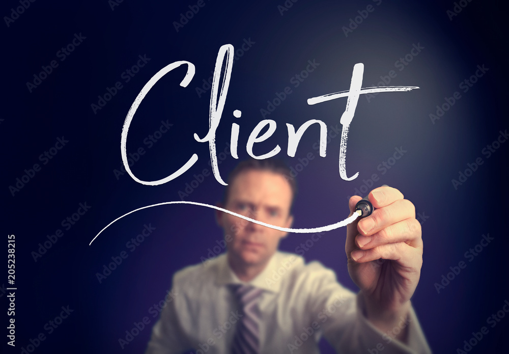 A businessman writing a Client concept with a white pen on a clear screen.