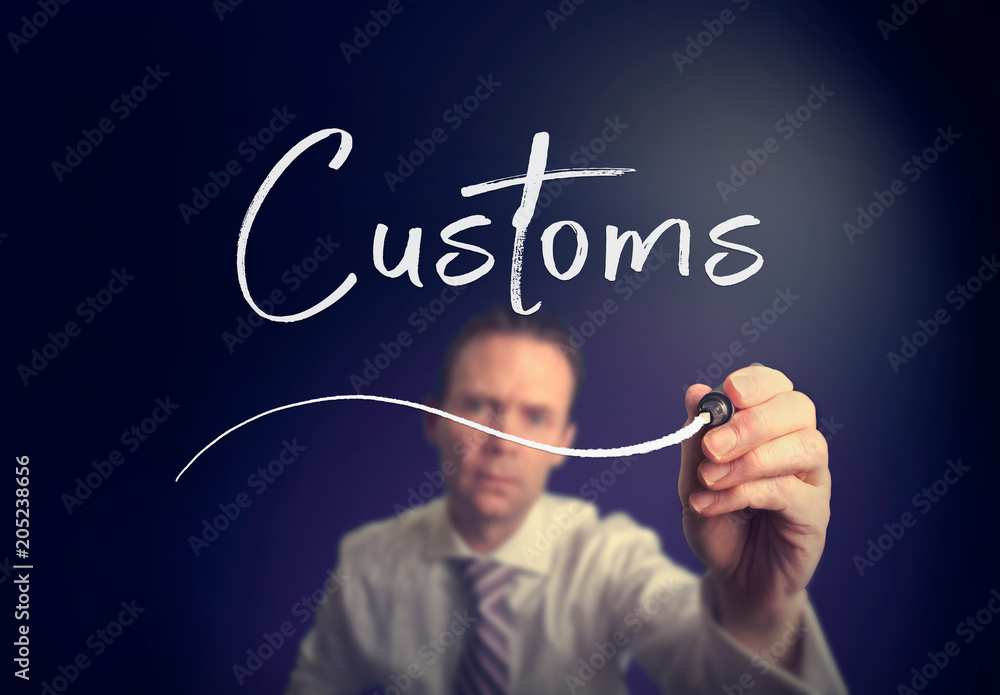 A businessman writing a Customs concept with a white pen on a clear screen. A businessman writing a Customs concept with a white pen on a clear screen.