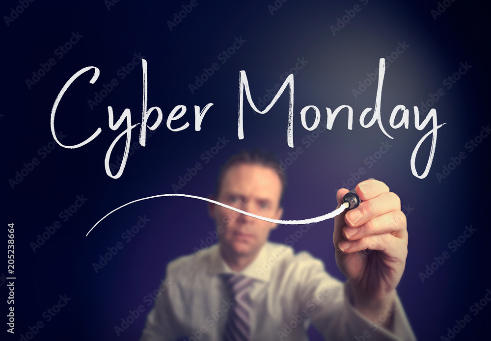 A businessman writing a Cyber Monday concept with a white pen on a clear screen. A businessman writing a Cyber Monday concept with a white pen on a clear screen.
