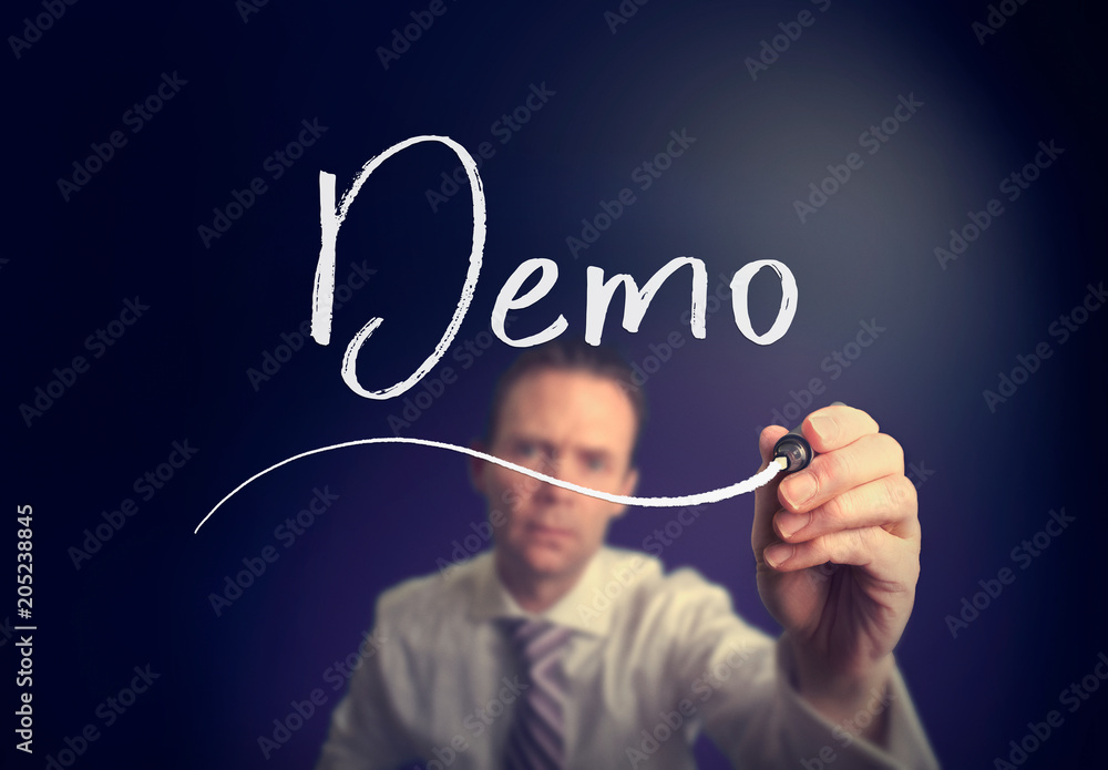 A businessman writing a Demo concept with a white pen on a clear screen. A businessman writing a Demo concept with a white pen on a clear screen.