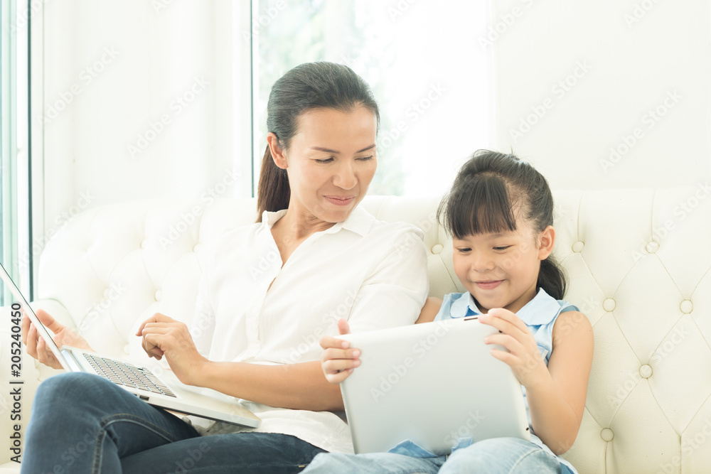 mother with daughter looking at Laptop on sofa mother with daughter looking at Laptop on sofa