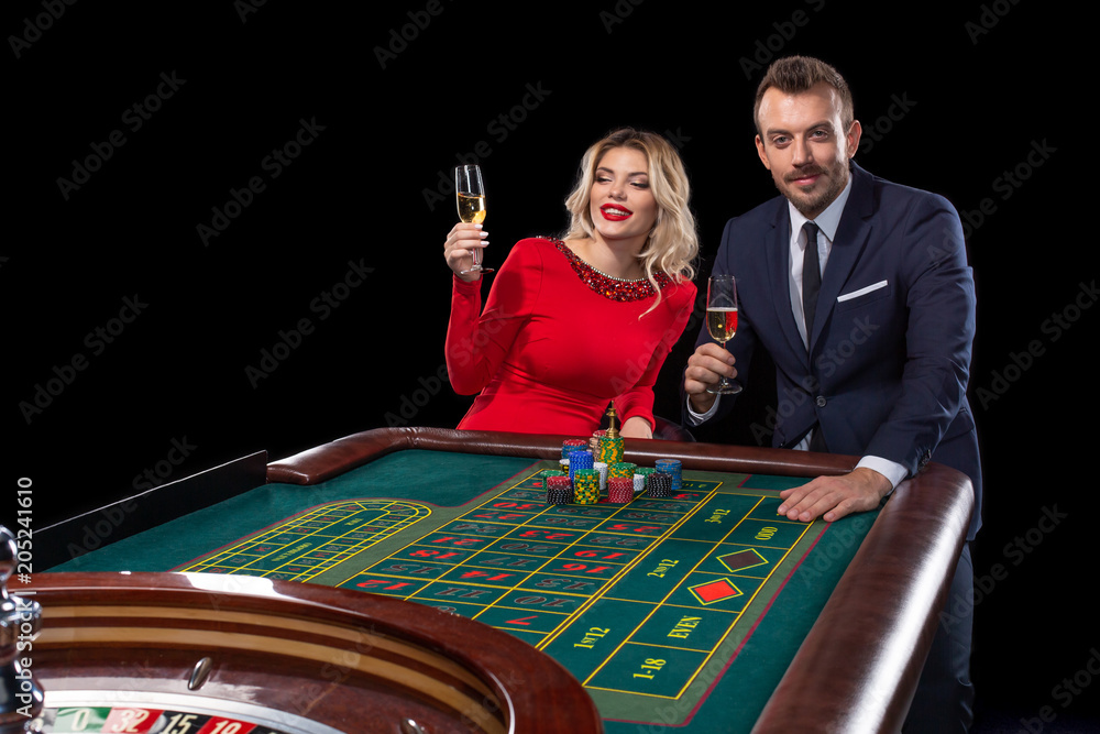 Beautiful and well dressed couple playing roulette in the casino Beautiful and well dressed couple playing roulette in the casino