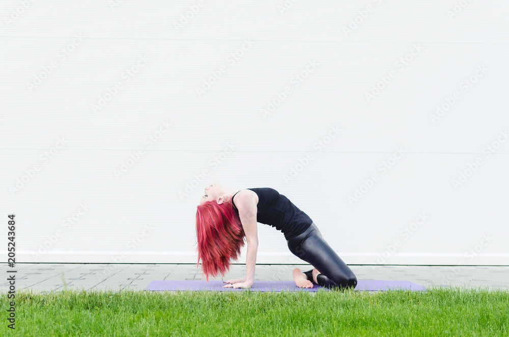 Fototapeta premium Woman stretching outdoors in a park