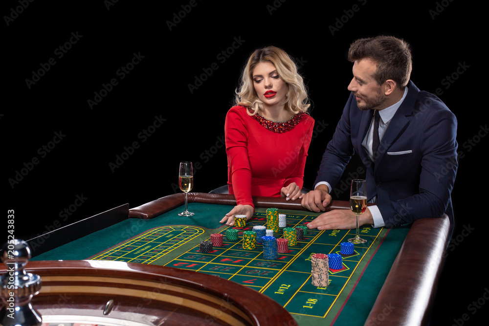 Beautiful and well dressed couple playing roulette in the casino Beautiful and well dressed couple playing roulette in the casino