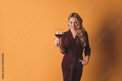 Slika na platnu Portrait of positive cheerful big-eyed woman in suit having glass with red wine,