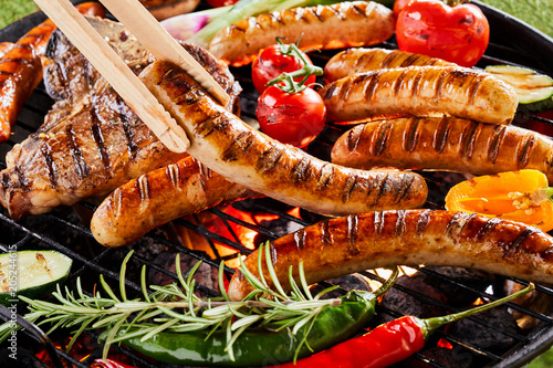 Φωτογραφία Summer barbecue with sizzling sausages over a fire