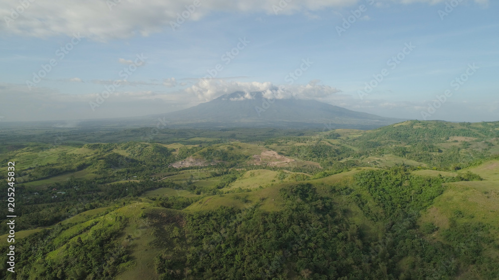 Fototapeta premium Aerial view of mountain valley with hillscovered forest, trees, mount Iriga. Luzon, Philippines. Slopes of mountains with evergreen vegetation. Mountainous tropical landscape.