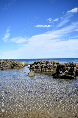 Beautiful view of the rocky coast of the Mediterranean Sea and the blue sky with white clouds