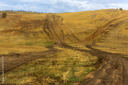 Track winding back roads in the mountains. Dirt road on Olkhon island in lake Baikal. photo