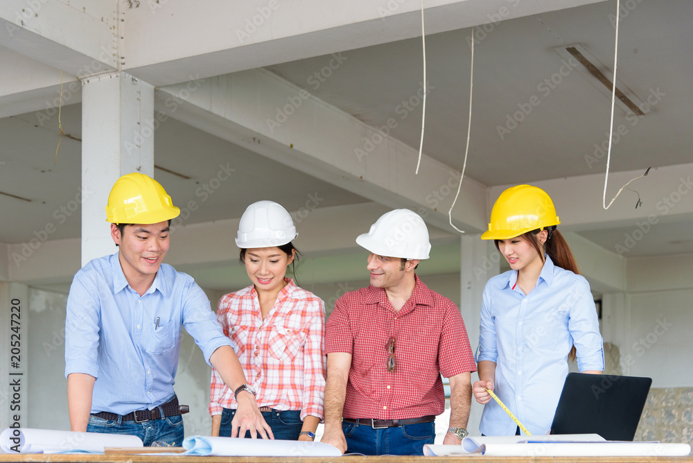 Group of Multiethnic engineers meeting about their project in construction site. Engineer present to his team about their project. Engineer and Construction concept. Group of Multiethnic engineers meeting about their project in construction site. Engineer present to his team about their project. Engineer and Construction concept.
