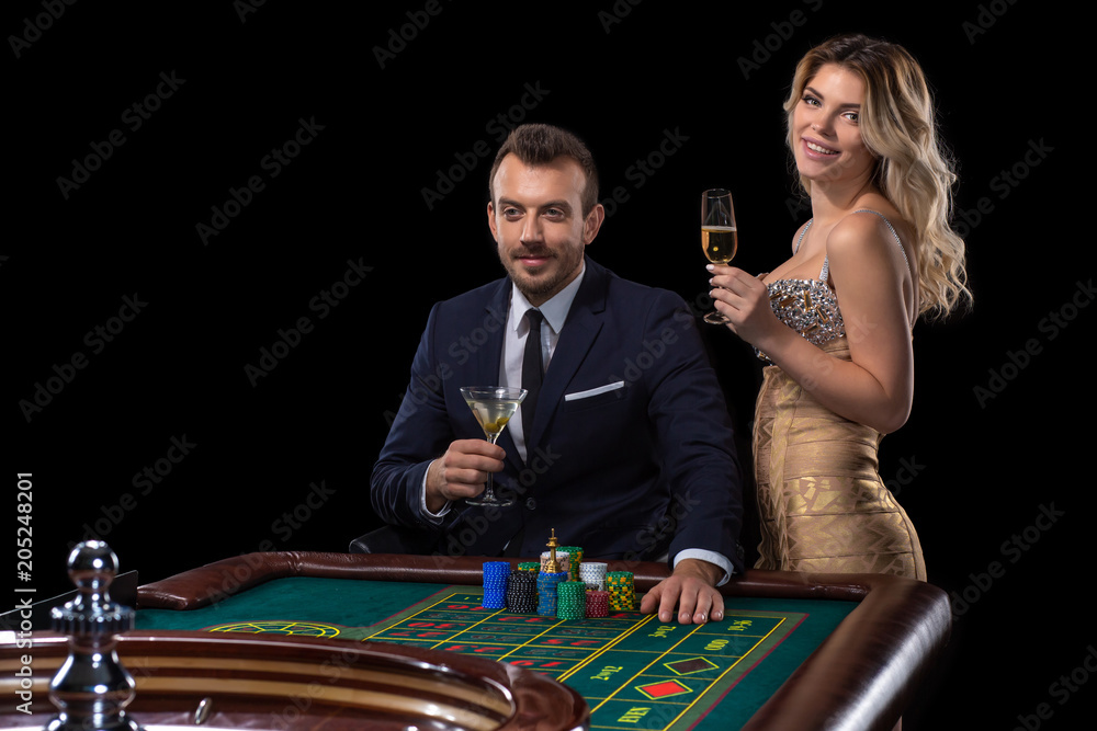 Couple gambling at roulette table in casino Couple gambling at roulette table in casino