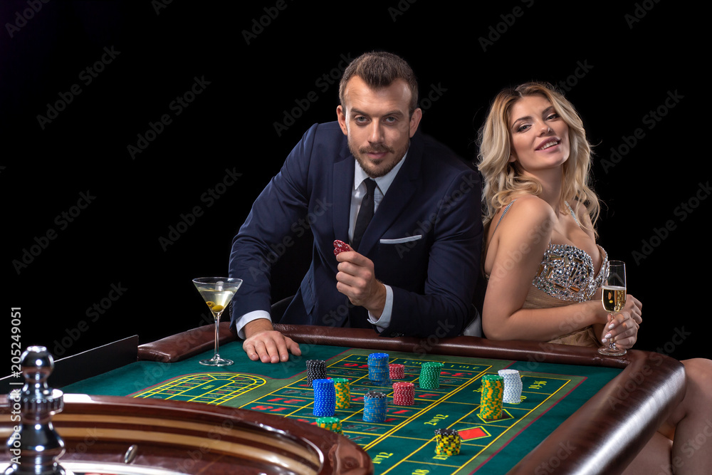 Couple gambling at roulette table in casino Couple gambling at roulette table in casino